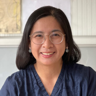 Anothai Thanachareonkit, a person with medium-length dark hair wearing glasses and a blue top.