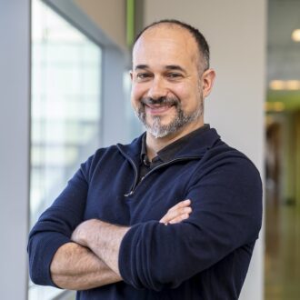 Hector Garcia Martin, a person wearing a dark blue quarter zip with their arms crossed.