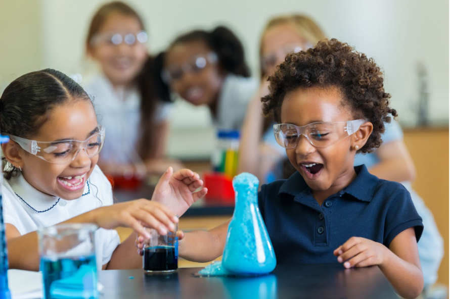 Children at a lab benchtop with a beaker.