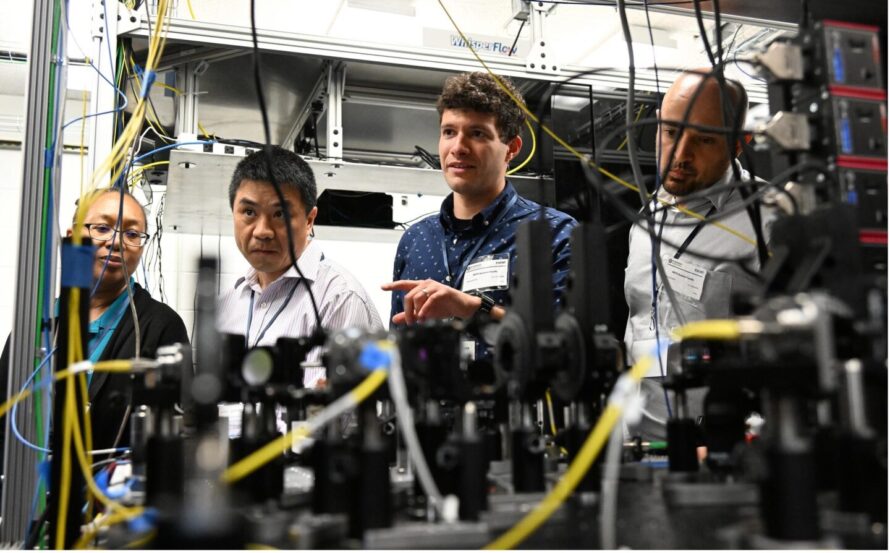 Four tour participants peering through various wires and instrumentation.